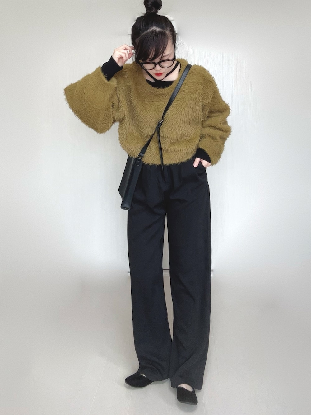 ブラック系のTシャツ/カットソー、グリーン系のニット/セーター、ブラック系のスラックスを着用したレディースの冬コーディネートの4枚目の写真