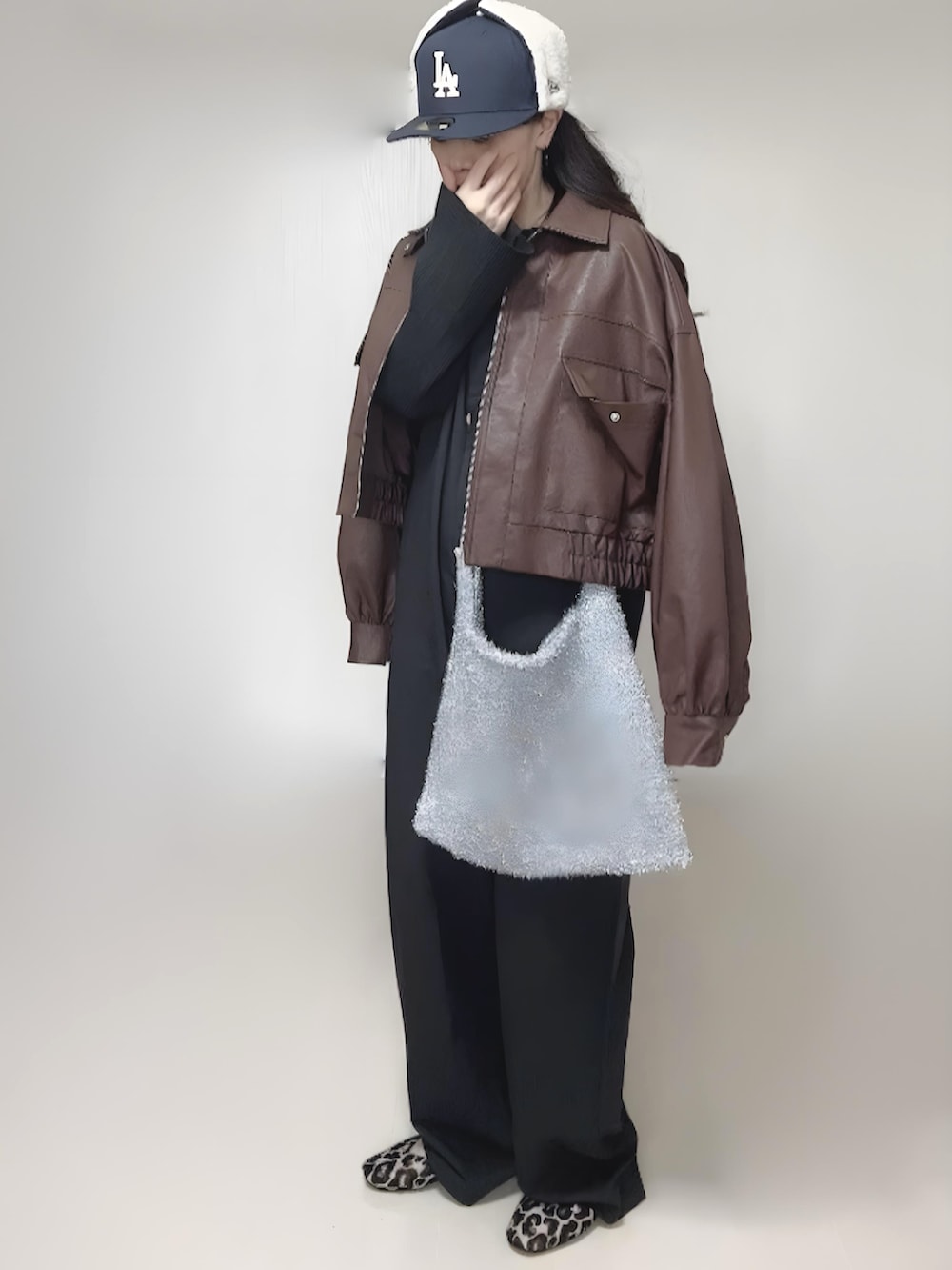 ブラック系のカーディガン/ボレロ、ブラウン系のブルゾン、ブラック系のつなぎ/オールインワンを着用したレディースの冬コーディネートの5枚目の写真