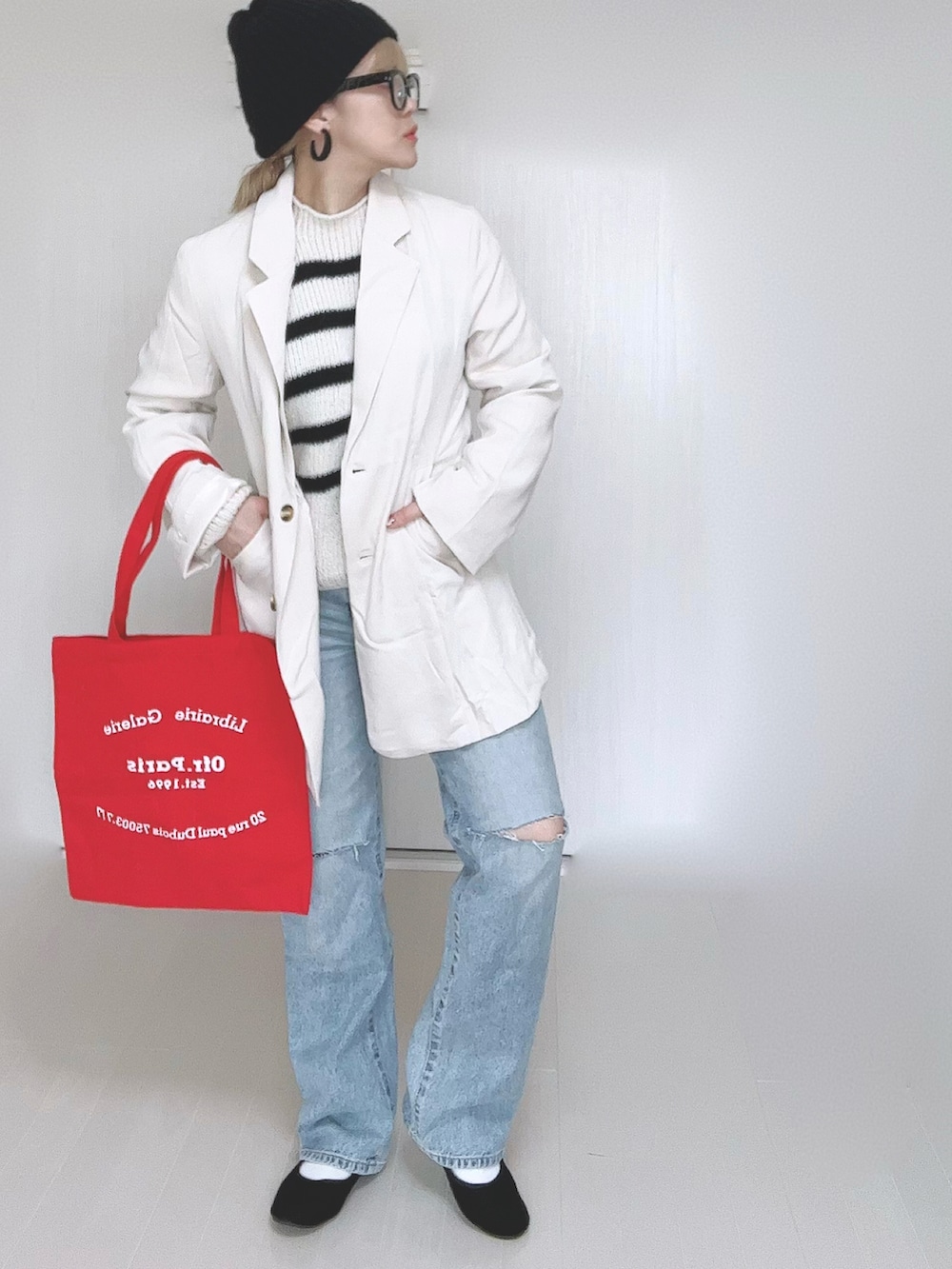 ホワイト系のテーラードジャケット、ホワイト系のニット/セーター、ブルー系のデニムパンツを着用したレディースの春コーディネートの2枚目の写真