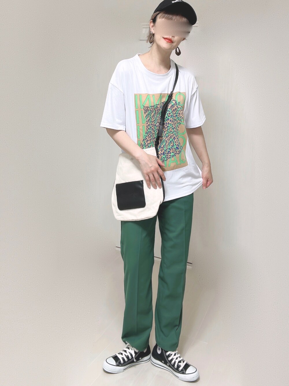 ホワイト系のショルダーバッグ、グリーン系のスラックス、ブラック系のスニーカーを着用したレディースの夏コーディネートの4枚目の写真