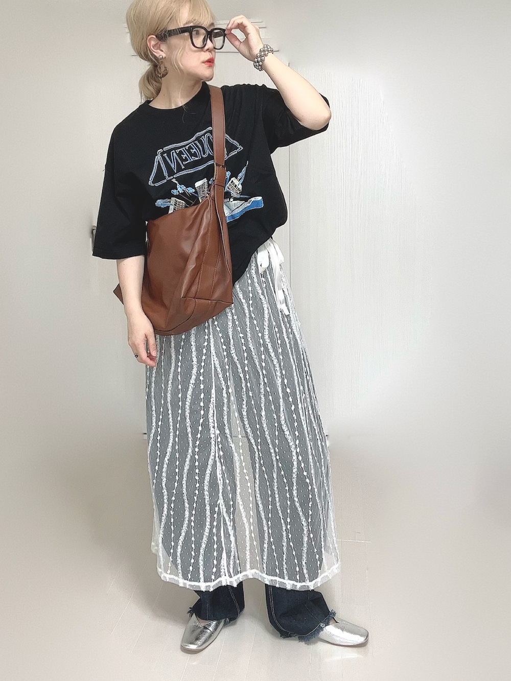 ブラック系のTシャツ/カットソー、ホワイト系のスカート、ブルー系のデニムパンツを着用したレディースの夏コーディネートの3枚目の写真