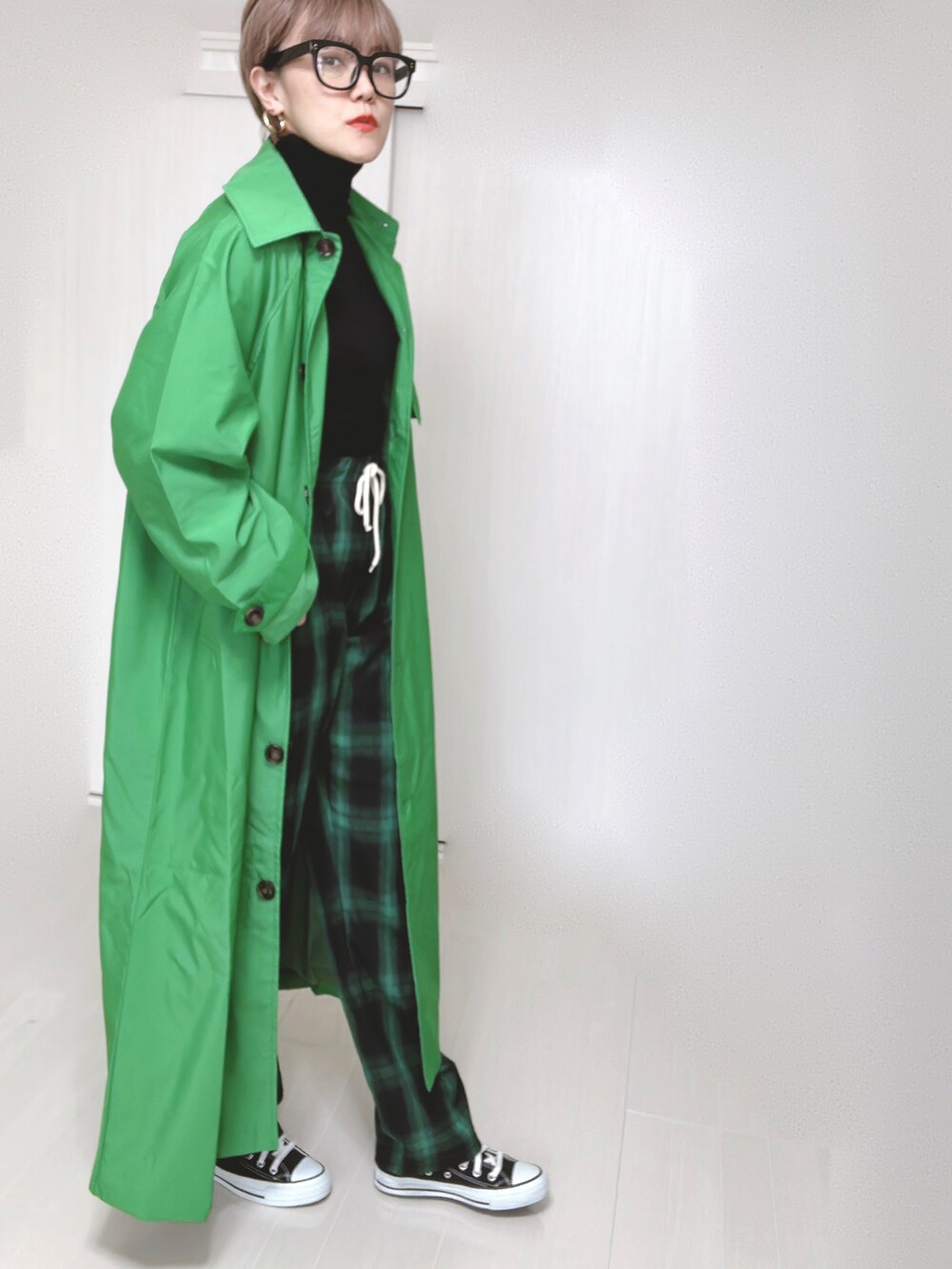 グリーン系のトレンチコート、グリーン系のその他パンツ、ブラック系のショルダーバッグを着用したレディースの春コーディネートの3枚目の写真