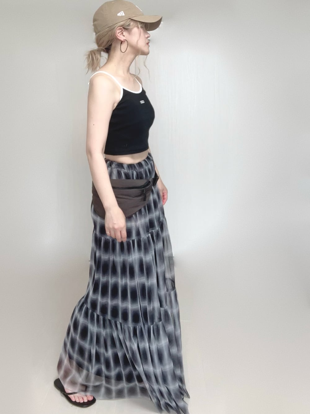 ブラック系のスカート、ブラック系のキャミソール、ブラック系のサンダルを着用したレディースの夏コーディネートの3枚目の写真