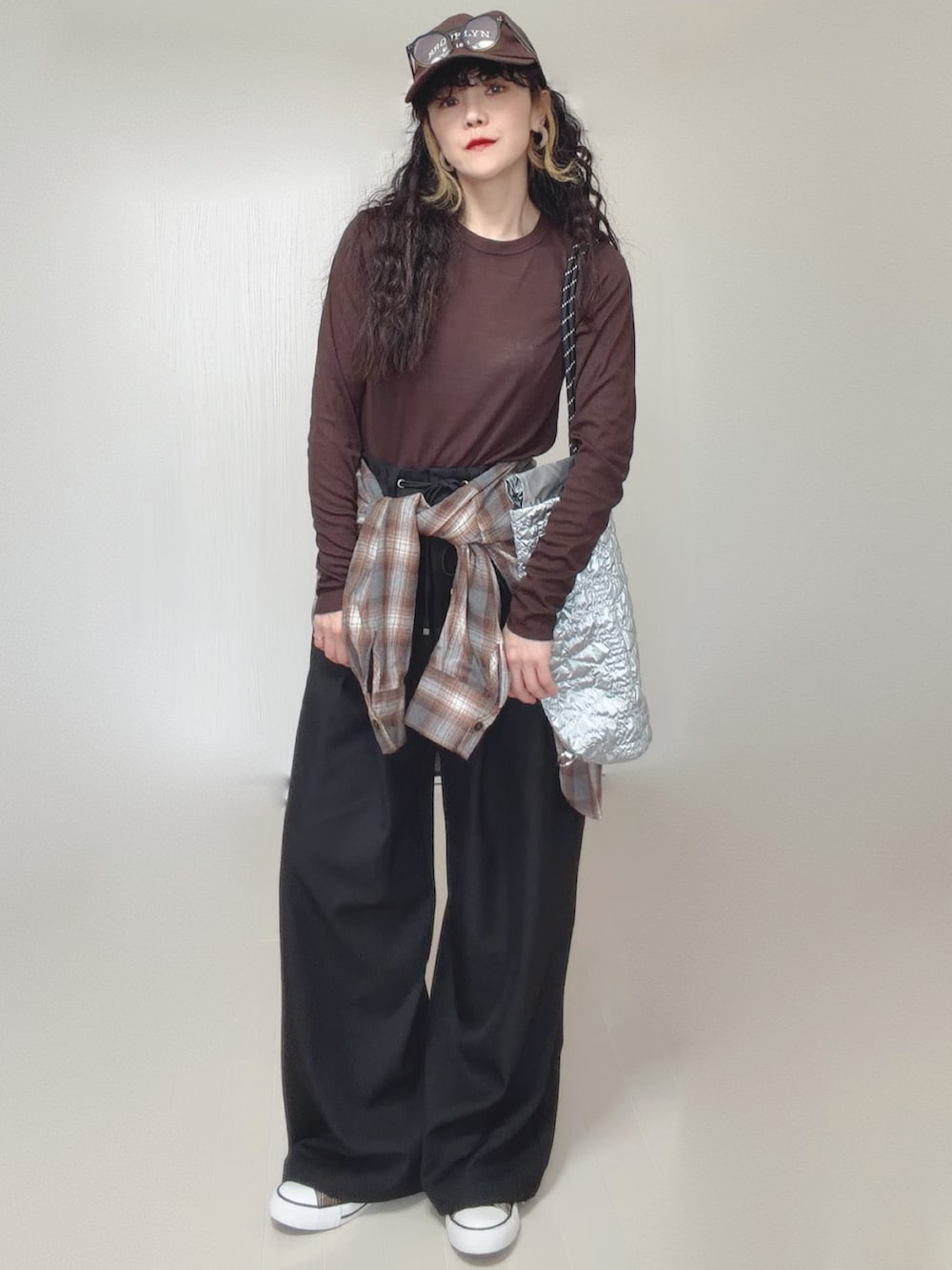 ブラウン系のシャツ/ブラウス、ブラック系のスラックス、シルバー系のトートバッグを着用したレディースの春コーディネートの5枚目の写真
