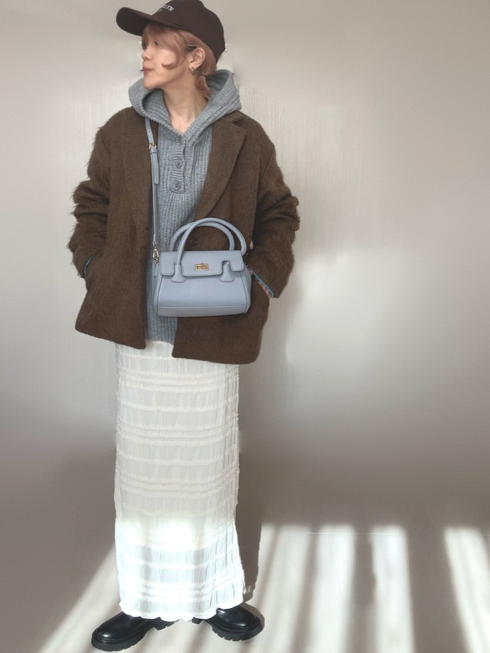 グレー系のニット/セーター、ブラック系のブーツ、ブラウン系のテーラードジャケットを着用したレディースの冬コーディネートの4枚目の写真