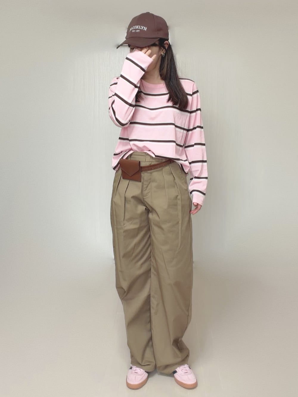 ベージュ系のチノパンツ、ブラウン系のベルトを着用したレディースの秋コーディネートの3枚目の写真