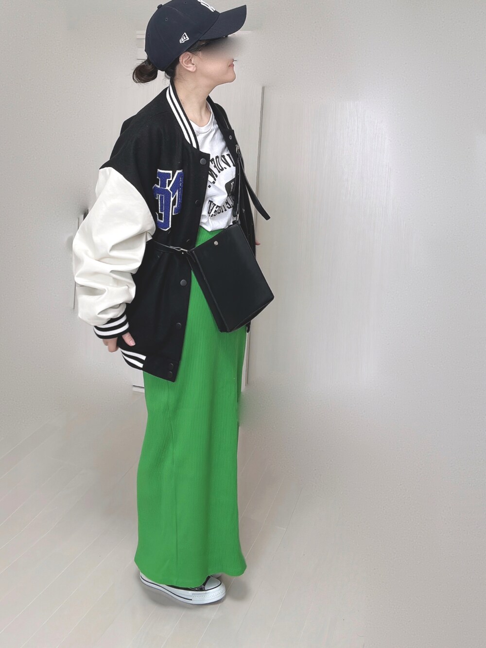 ブラック系のスタジャン、ホワイト系のTシャツ/カットソー、グリーン系のスカートを着用したレディースの冬コーディネートの3枚目の写真