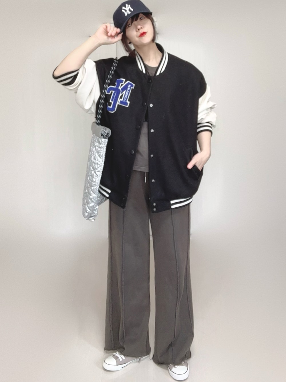 ブラック系のスウェットパンツ、ブラック系のスタジャン、シルバー系のトートバッグを着用したレディースの春コーディネートの3枚目の写真