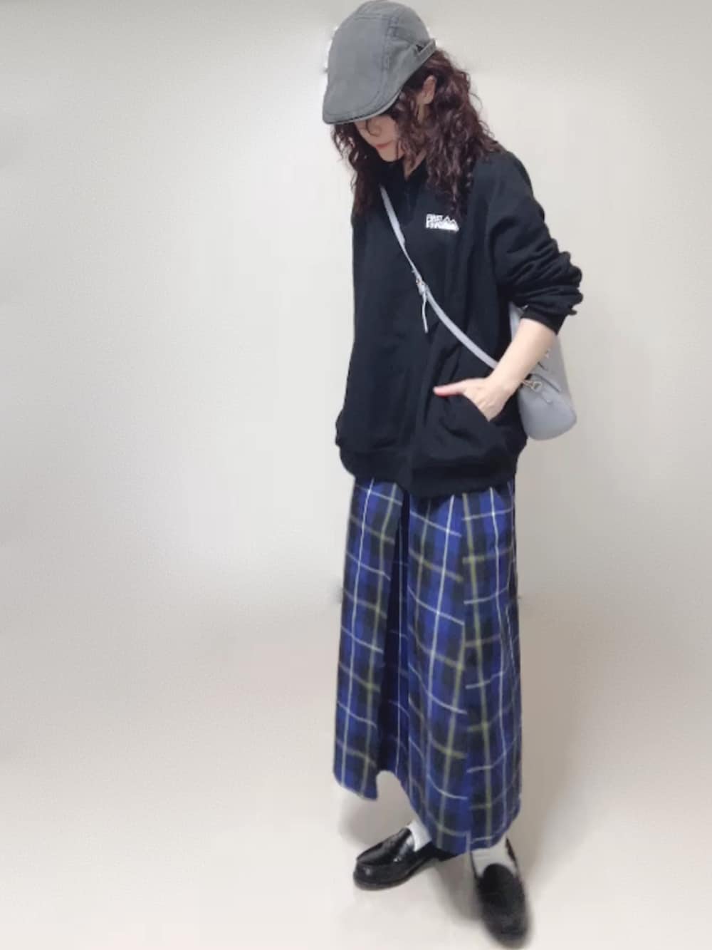 ブラック系のスウェット、ブラック系のローファー、グレー系のハンチング/ベレー帽を着用したレディースの秋コーディネートの3枚目の写真