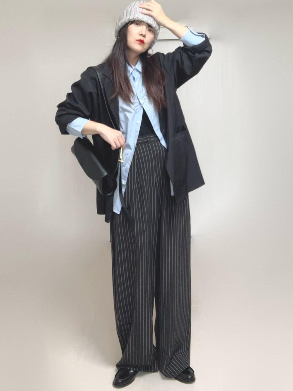 ブラック系のテーラードジャケット、ブラック系のローファー、ブラック系のスラックスを着用したレディースの秋コーディネートの4枚目の写真