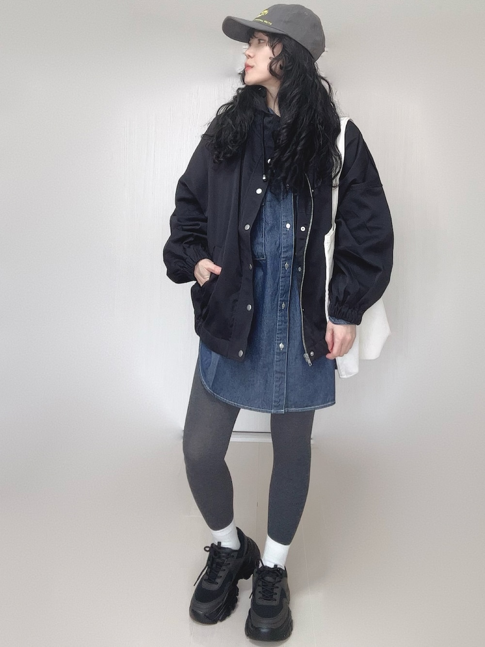 ブルー系のシャツ/ブラウス、ブラック系のマウンテンパーカー、ホワイト系のトートバッグを着用したレディースの春コーディネートの5枚目の写真