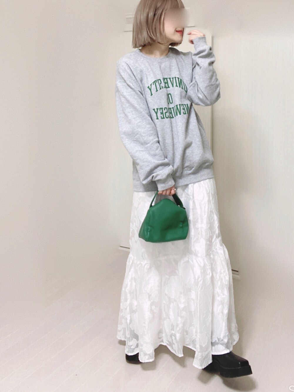 ホワイト系のスカート、グレー系のスウェット、グリーン系のハンドバッグを着用したレディースの秋コーディネートの5枚目の写真