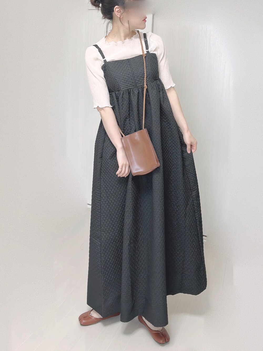 ブラック系のワンピース、ベージュ系のTシャツ/カットソー、ブラウン系のショルダーバッグを着用したレディースの春コーディネートの5枚目の写真