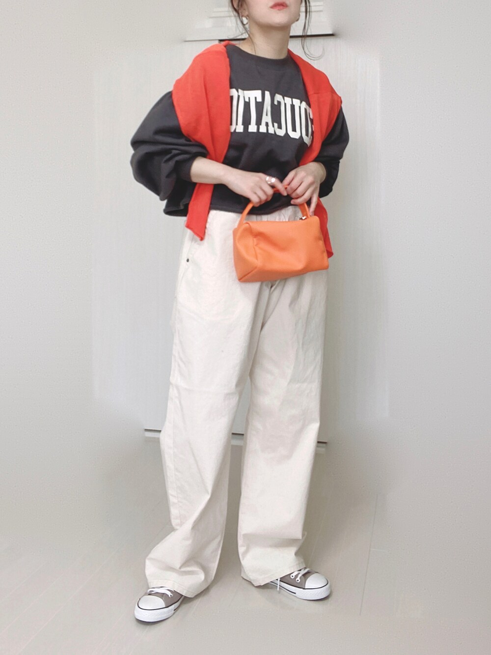 ホワイト系のその他パンツ、オレンジ系のカーディガン/ボレロ、オレンジ系のショルダーバッグを着用したレディースの春コーディネートの2枚目の写真