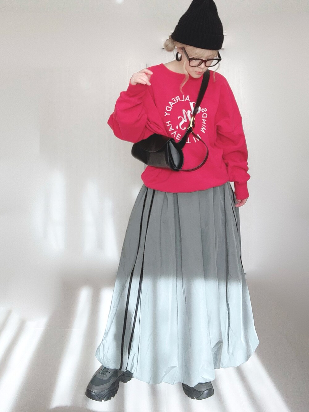 レッド系のスウェット、ブラック系のブーツを着用したレディースの冬コーディネートの4枚目の写真