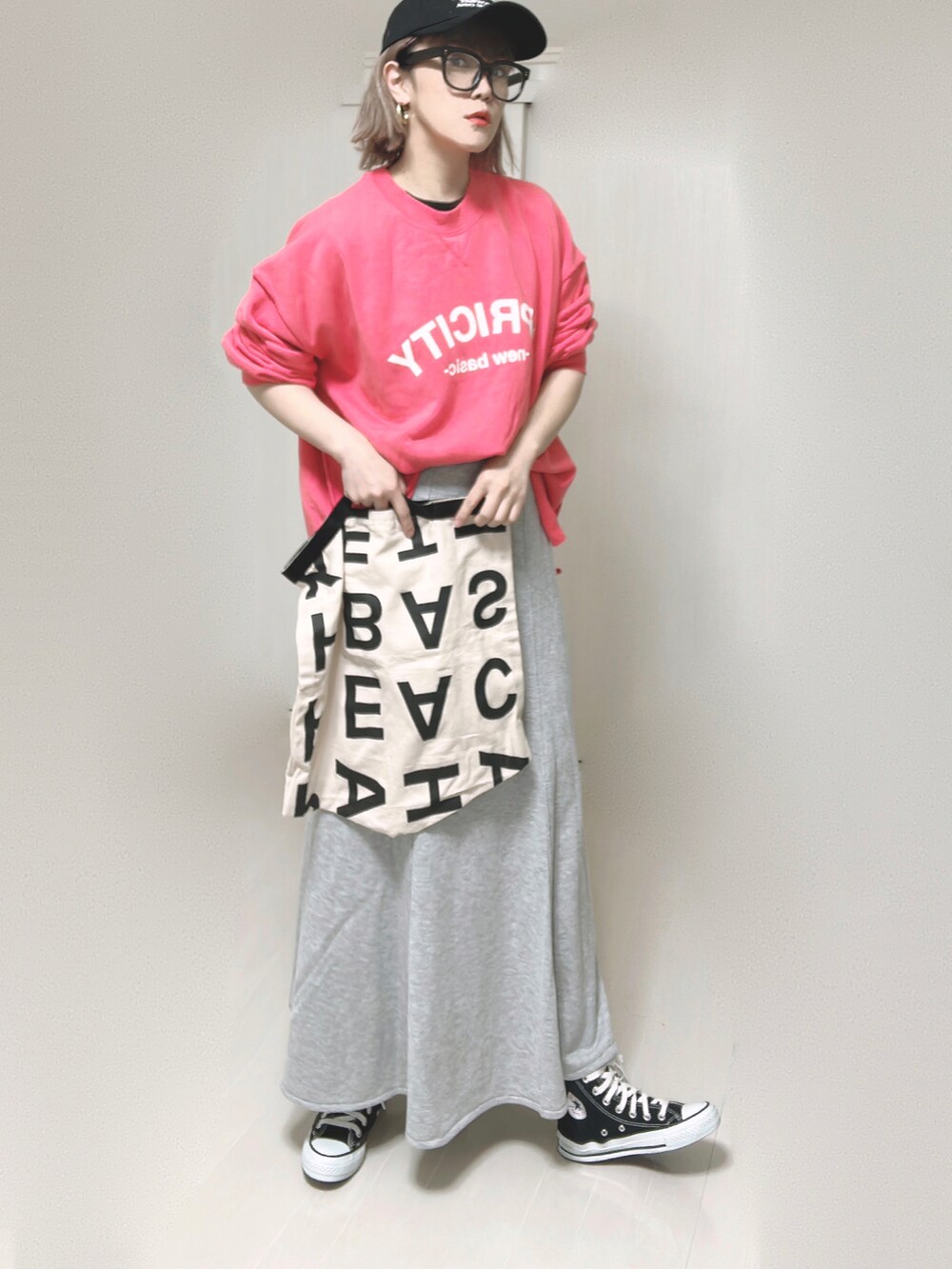 ピンク系のスウェット、ホワイト系のトートバッグ、グレー系のスカートを着用したレディースの夏コーディネートの4枚目の写真