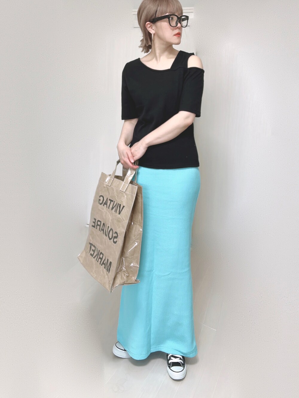 ブラック系のTシャツ/カットソー、ブルー系のスカート、グリーン系のトートバッグを着用したレディースの夏コーディネートの4枚目の写真