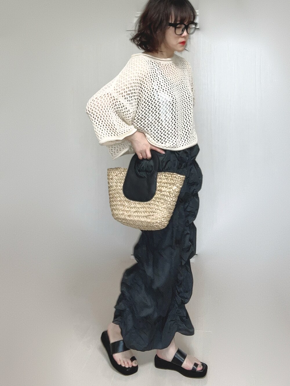 グレー系のスカート、シルバー系のタンクトップ、ベージュ系のニット/セーターを着用したレディースの春コーディネートの3枚目の写真