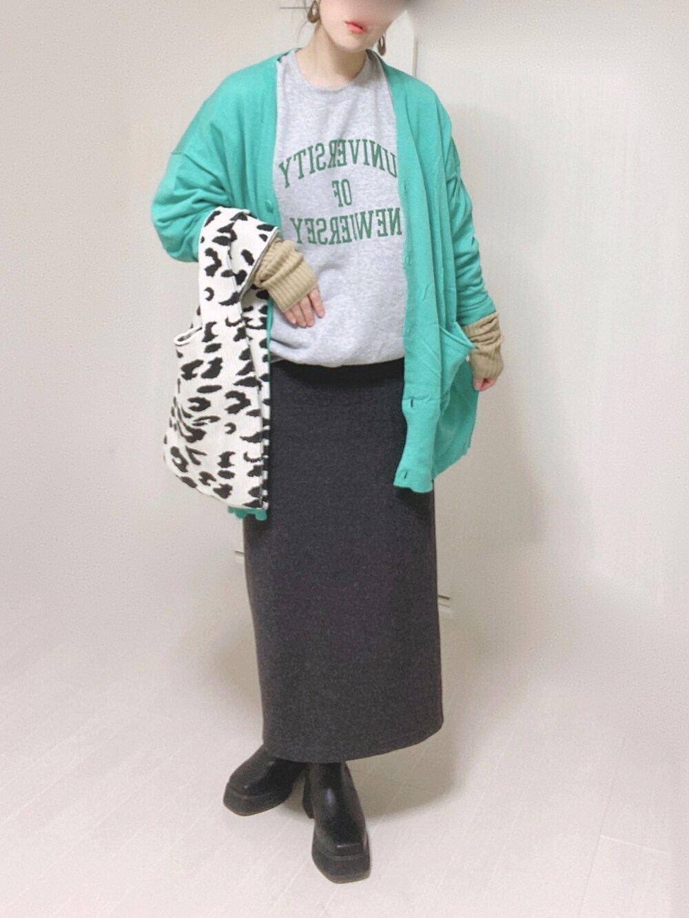 グレー系のスウェット、グリーン系のカーディガン/ボレロ、ブラック系のブーツを着用したレディースの冬コーディネートの5枚目の写真