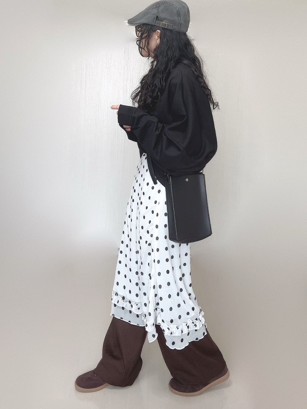 ブラック系のスウェット、ブラウン系のその他パンツ、ブラック系のショルダーバッグを着用したレディースの春コーディネートの4枚目の写真