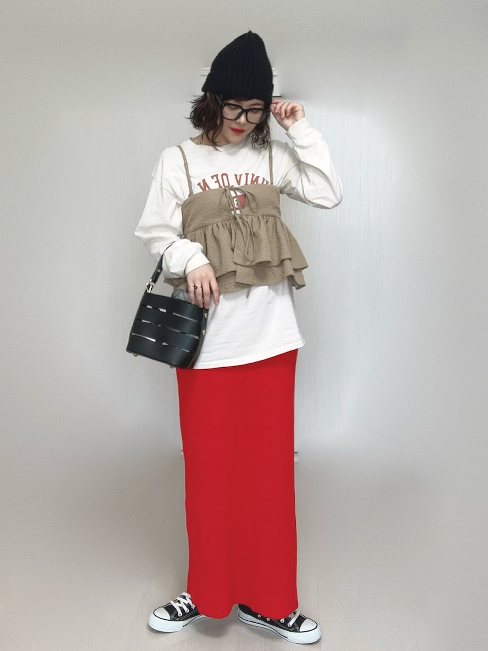 ベージュ系のキャミソール、ベージュ系のTシャツ/カットソー、ブラック系のショルダーバッグを着用したレディースの春コーディネートの2枚目の写真