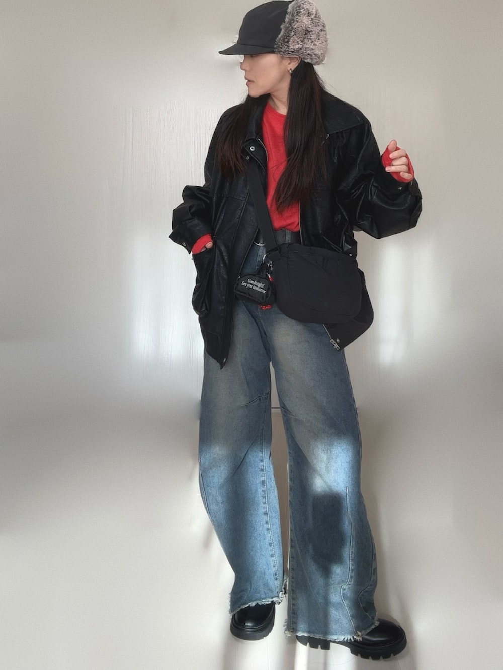 ブラック系のブルゾン、レッド系のTシャツ/カットソー、ブラック系のブーツを着用したレディースの冬コーディネートの2枚目の写真