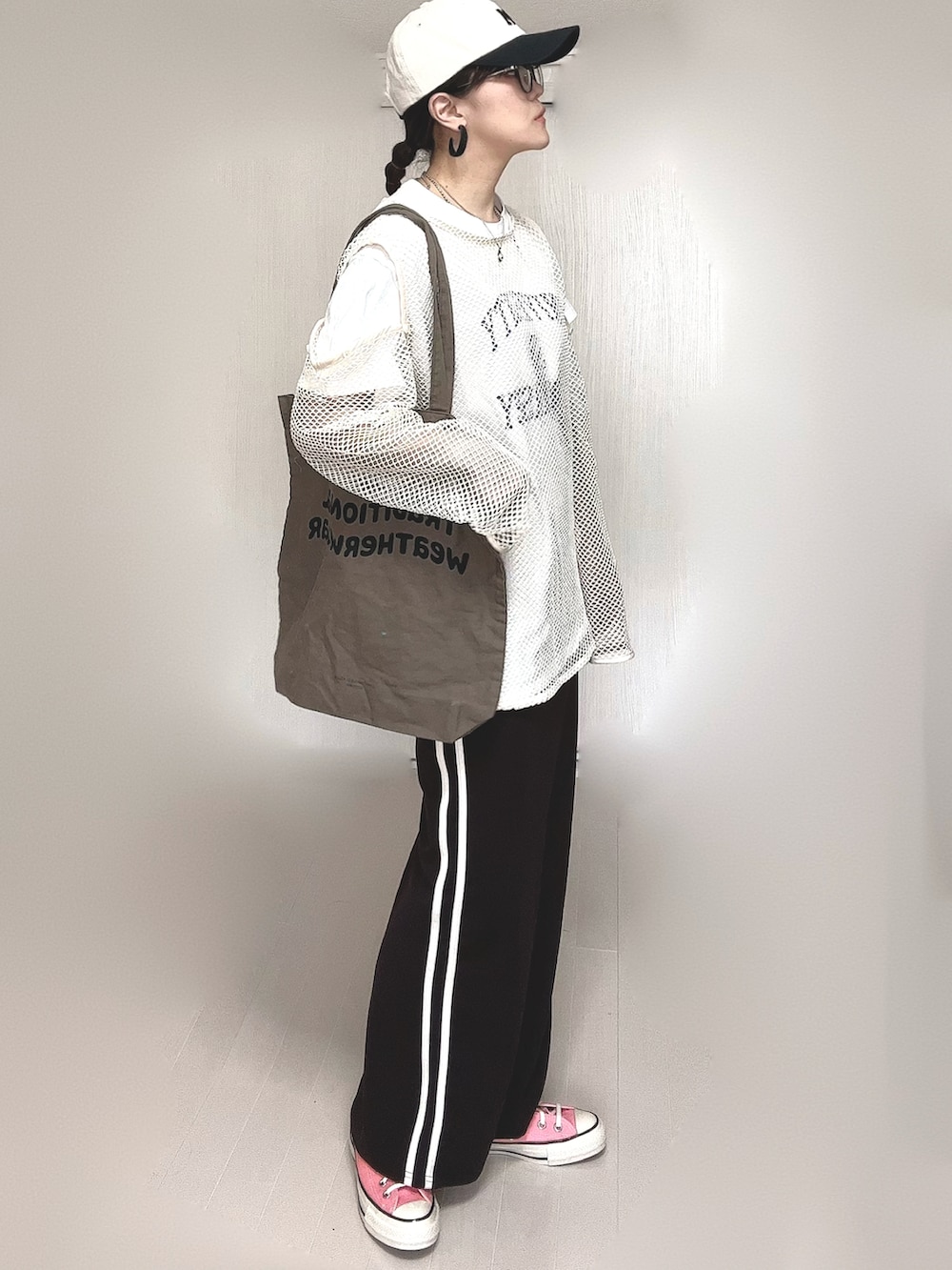 ホワイト系のTシャツ/カットソー、ブラウン系のトートバッグ、ピンク系のスニーカーを着用したレディースの春コーディネートの3枚目の写真