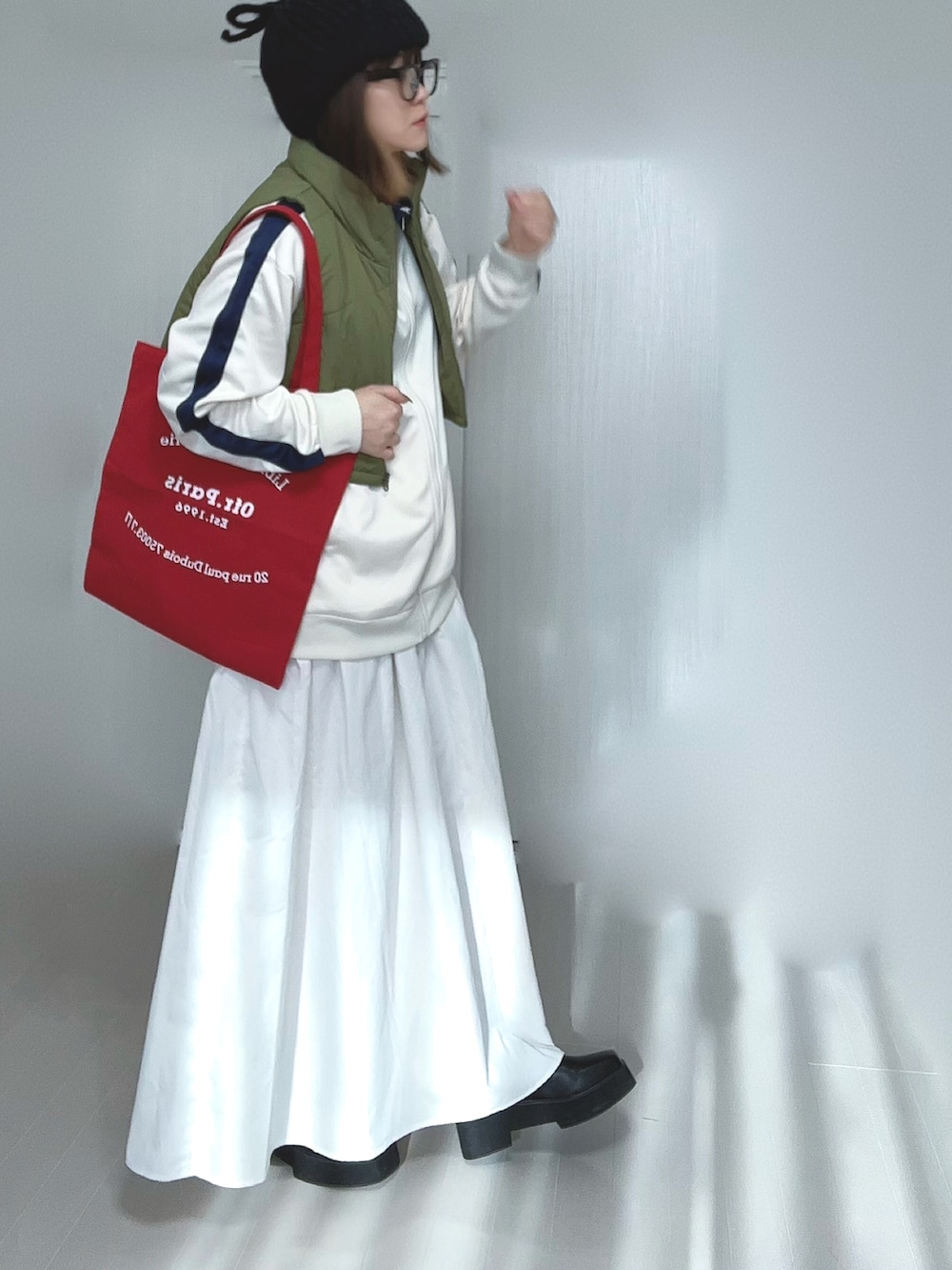 ベージュ系のジャージ、ホワイト系のスカート、ブラック系のブーツを着用したレディースの冬コーディネートの3枚目の写真