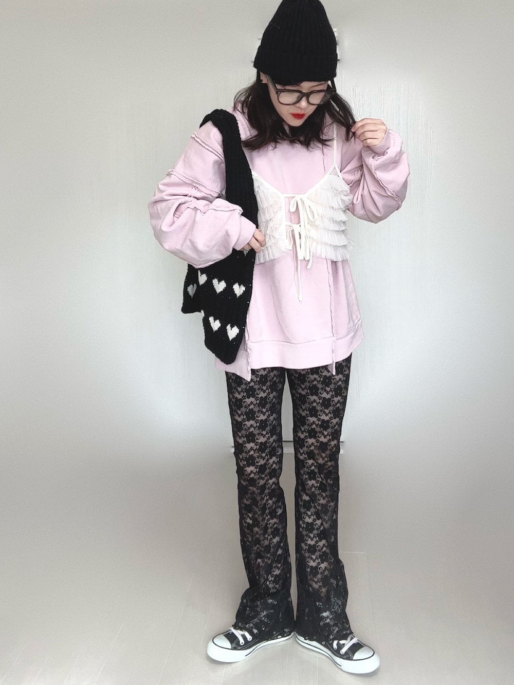 ピンク系のスウェット、ブラック系のその他パンツ、ブラック系のスニーカーを着用したレディースの冬コーディネートの4枚目の写真