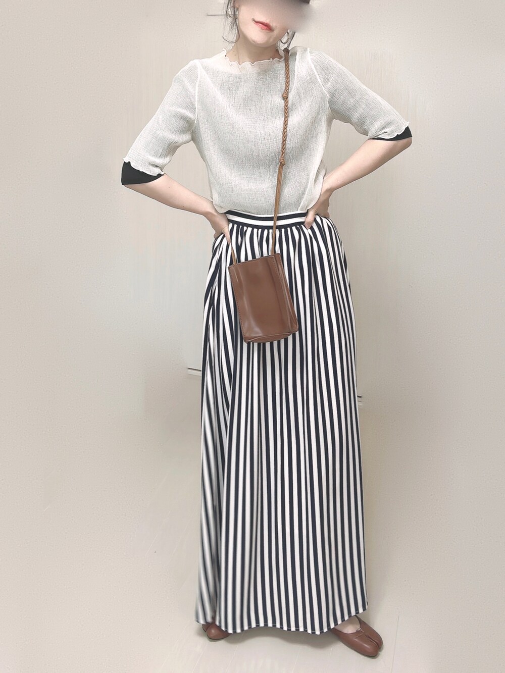 ブルー系のスカート、ブラック系のTシャツ/カットソー、ベージュ系のTシャツ/カットソーを着用したレディースの春コーディネートの4枚目の写真