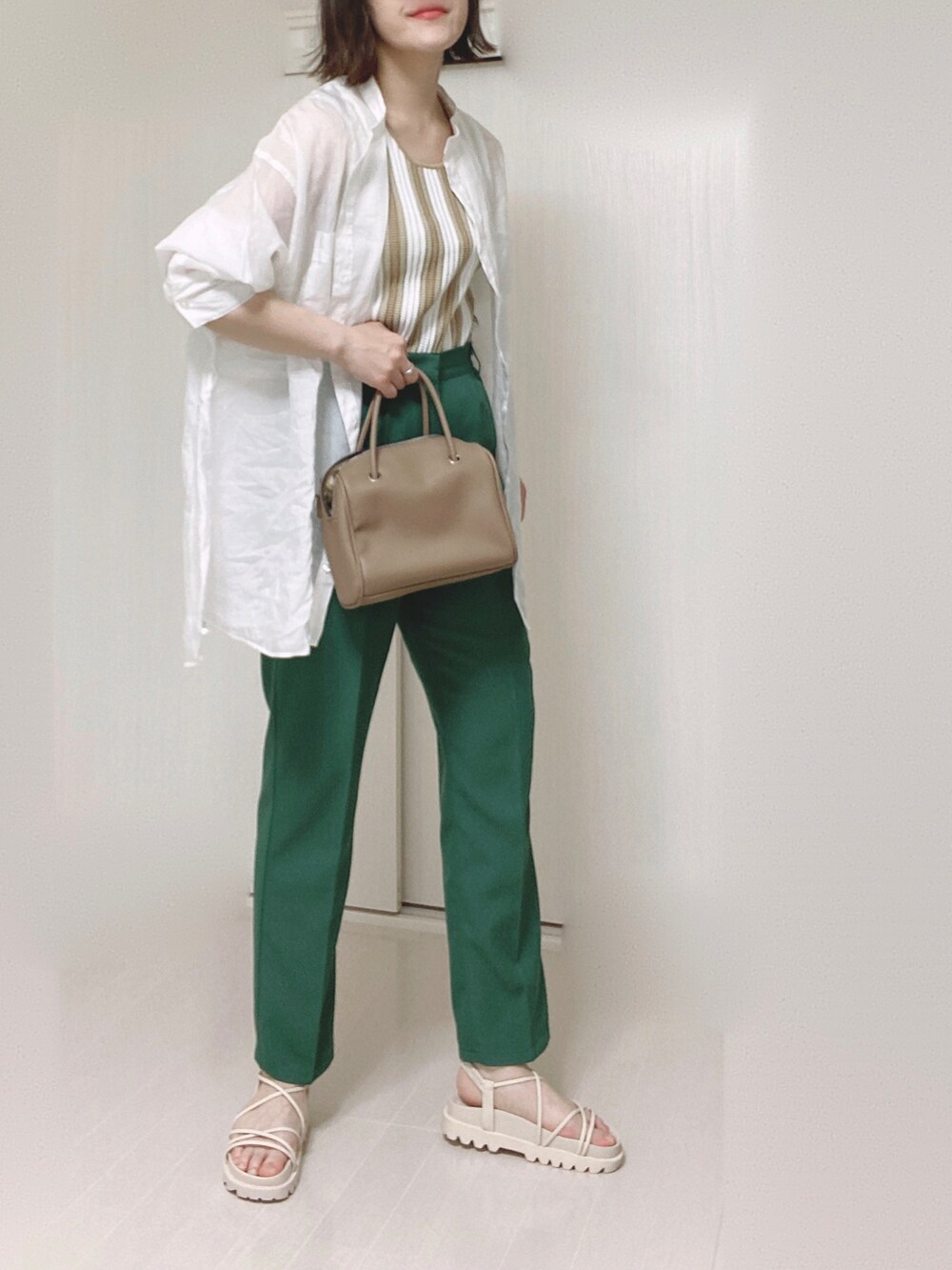 ホワイト系のサンダル、ホワイト系のシャツ/ブラウス、ベージュ系のタンクトップを着用したレディースの春コーディネートの2枚目の写真