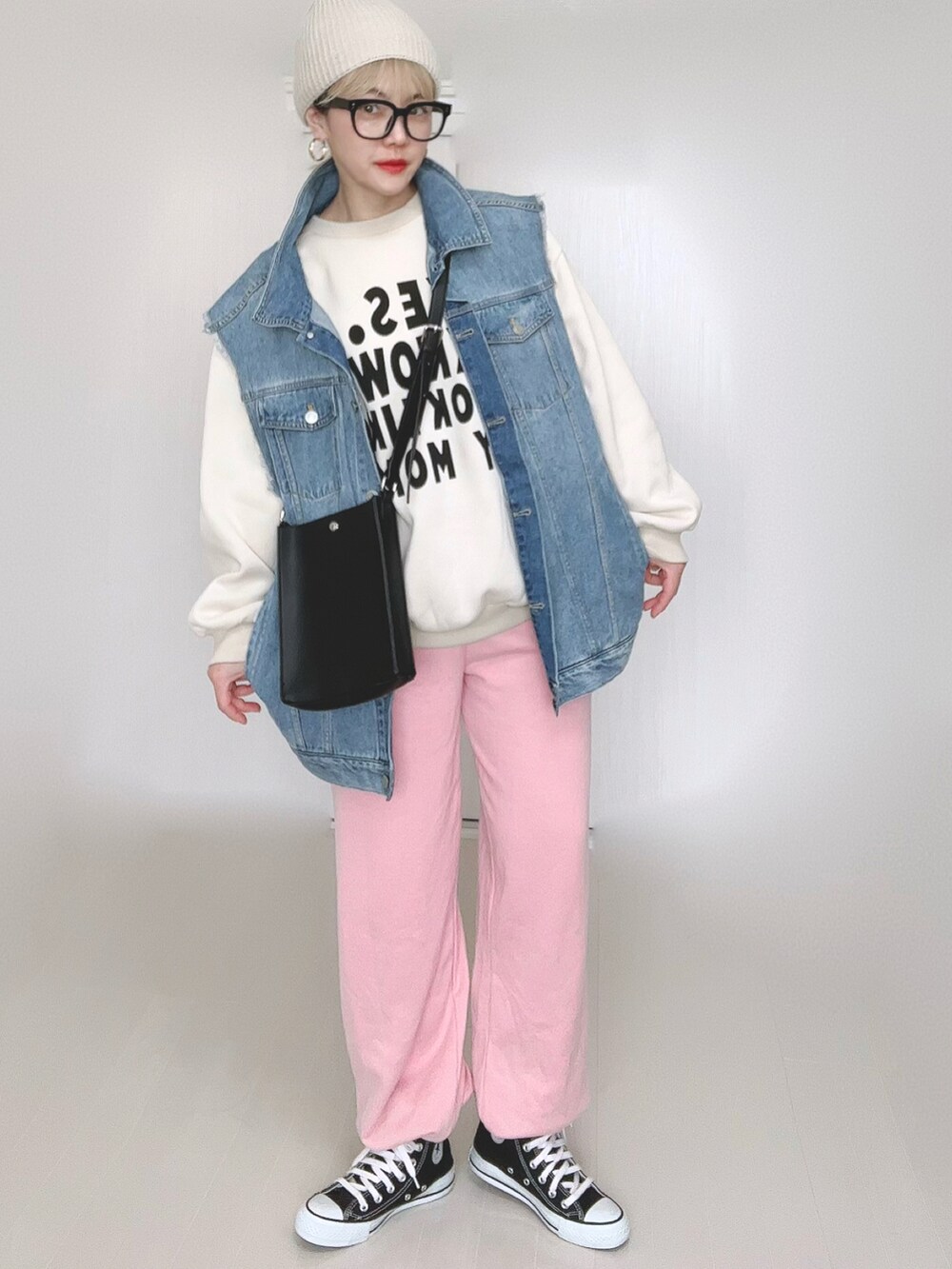 ブルー系のベスト、ブラック系のショルダーバッグ、ピンク系のスウェットパンツを着用したレディースの冬コーディネートの4枚目の写真