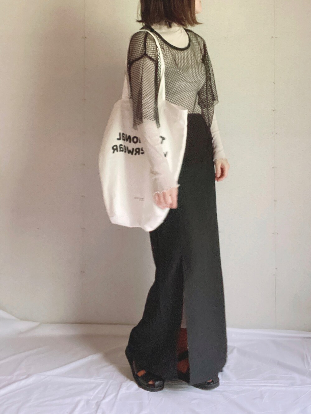 ブラック系のスカート、グレー系のTシャツ/カットソー、ホワイト系のトートバッグを着用したレディースの夏コーディネートの5枚目の写真