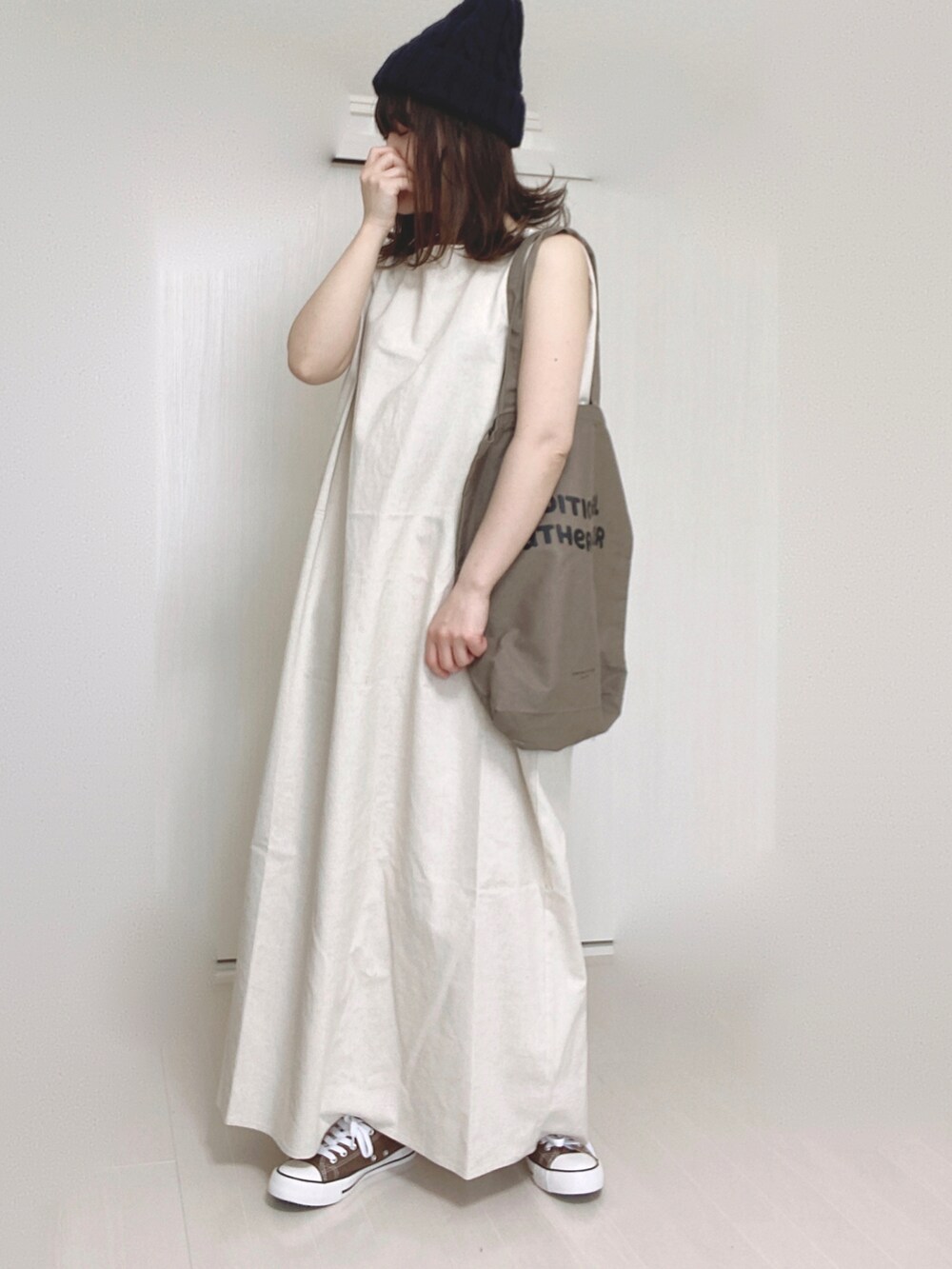 ホワイト系のワンピース、ブラウン系のトートバッグ、ブルー系のニットキャップ/ビーニーを着用したレディースの春コーディネートの4枚目の写真