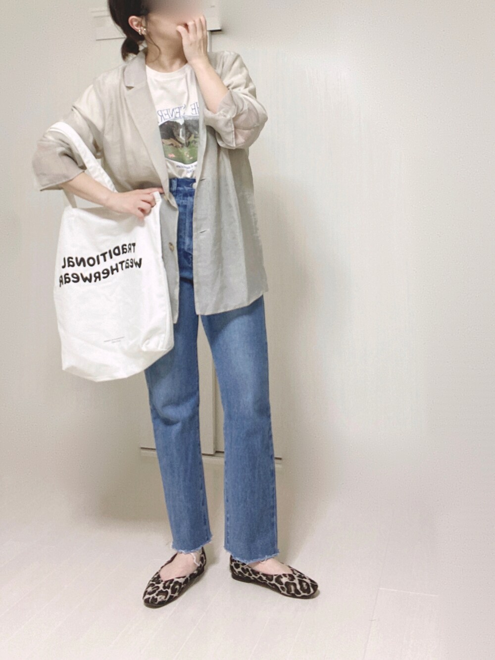 グレー系のテーラードジャケット、ホワイト系のTシャツ/カットソー、ブルー系のデニムパンツを着用したレディースの夏コーディネートの5枚目の写真