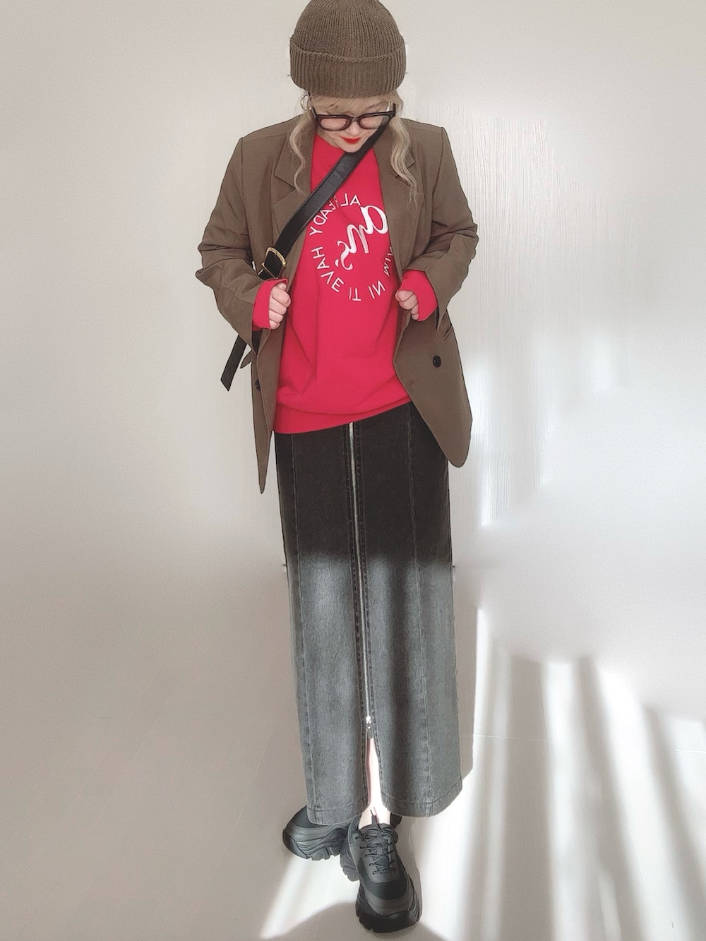 ブラック系のスカート、ブラウン系のテーラードジャケット、レッド系のスウェットを着用したレディースの冬コーディネートの4枚目の写真