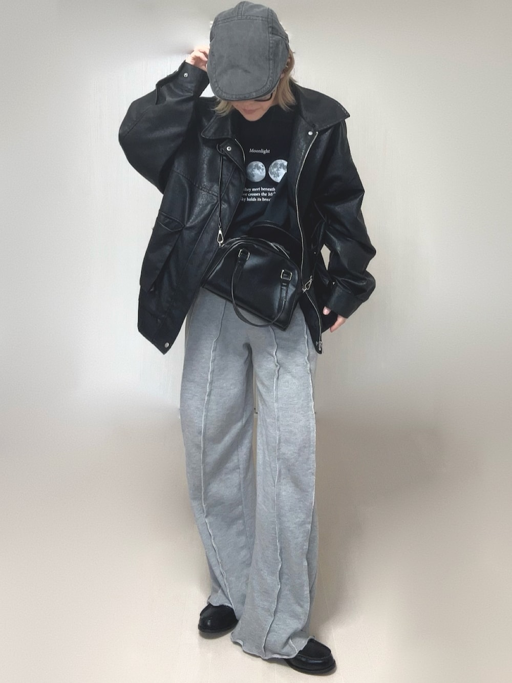 ブラック系のブルゾン、ブラック系のTシャツ/カットソー、グレー系のスウェットパンツを着用したレディースの冬コーディネートの5枚目の写真