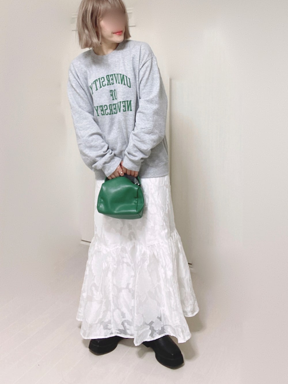 ホワイト系のスカート、グレー系のスウェット、グリーン系のハンドバッグを着用したレディースの秋コーディネートの4枚目の写真