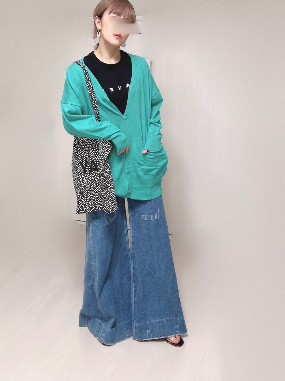 グリーン系のカーディガン/ボレロ、ブラック系のTシャツ/カットソー、ブラック系のサンダルを着用したレディースの春コーディネートの3枚目の写真