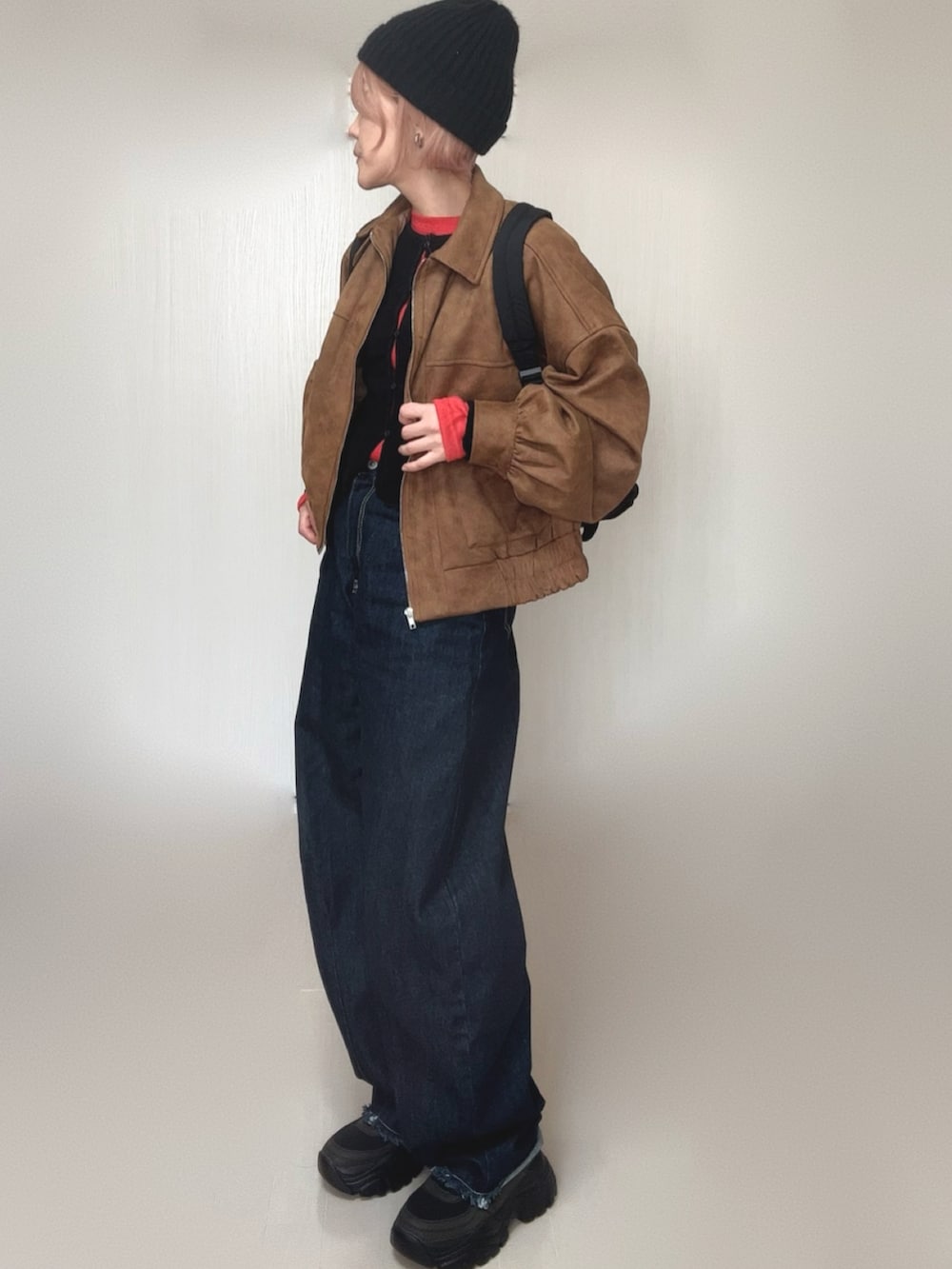 ブラック系のカーディガン/ボレロ、ベージュ系のブルゾン、レッド系のTシャツ/カットソーを着用したレディースの冬コーディネートの2枚目の写真