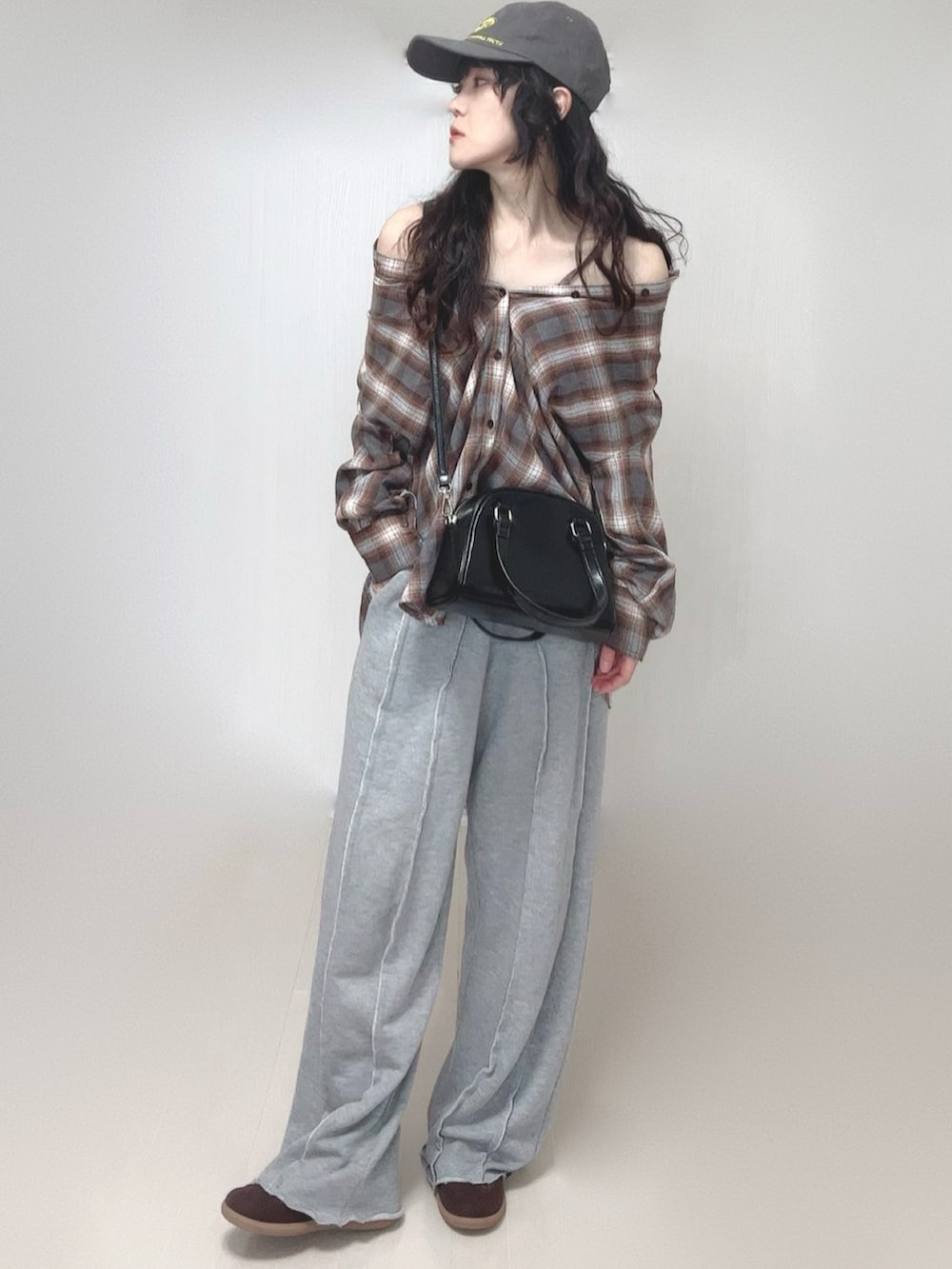 ブラウン系のシャツ/ブラウス、グレー系のスウェットパンツ、ブラック系のボストンバッグを着用したレディースの春コーディネートの4枚目の写真