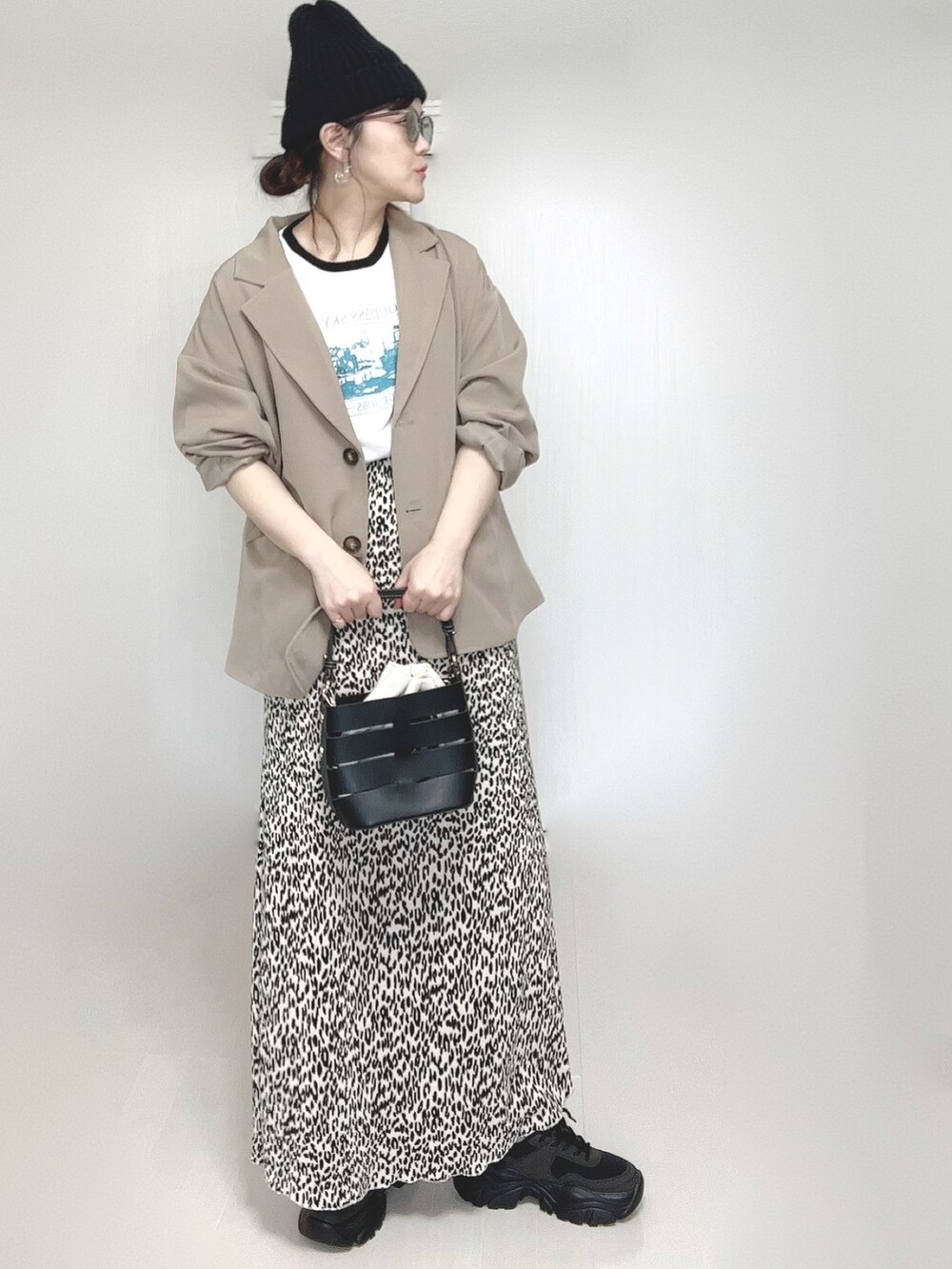 ホワイト系のTシャツ/カットソー、ベージュ系のセットアップ、ブラック系のショルダーバッグを着用したレディースの春コーディネートの4枚目の写真