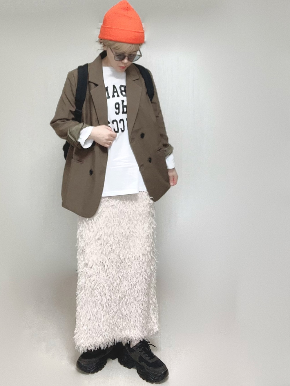 ホワイト系のTシャツ/カットソー、ブラウン系のテーラードジャケット、ブラック系のスニーカーを着用したレディースの春コーディネートの2枚目の写真