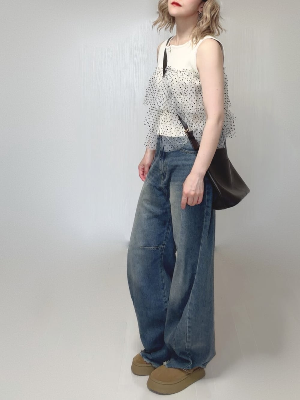 ブルー系のデニムパンツ、ホワイト系のニット/セーター、ベージュ系のシューズを着用したレディースの夏コーディネートの4枚目の写真
