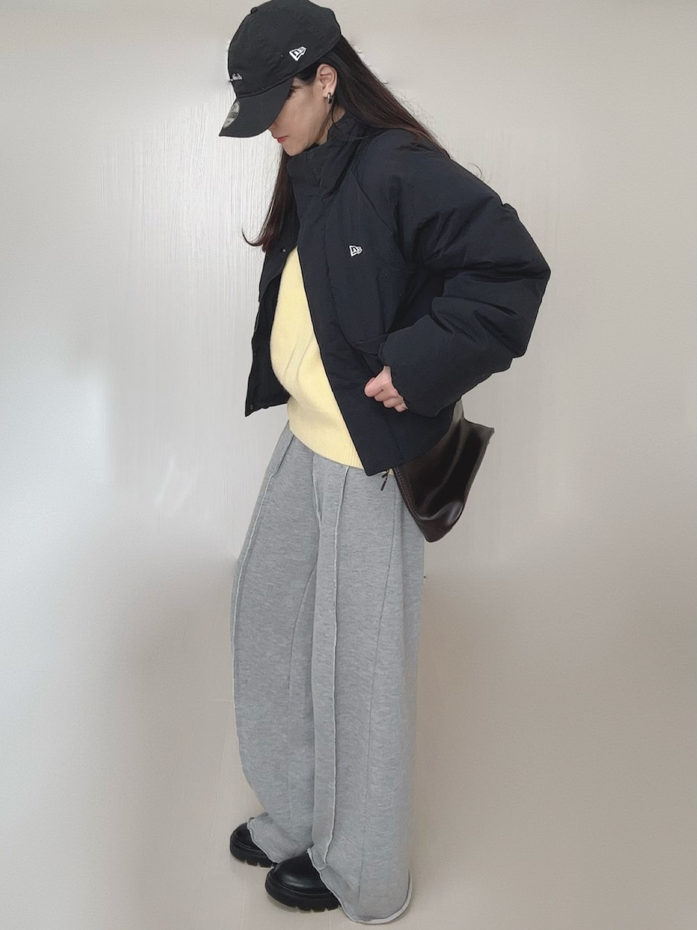 イエロー系のニット/セーター、グレー系のスウェットパンツ、ブラック系のブーツを着用したレディースの冬コーディネートの4枚目の写真