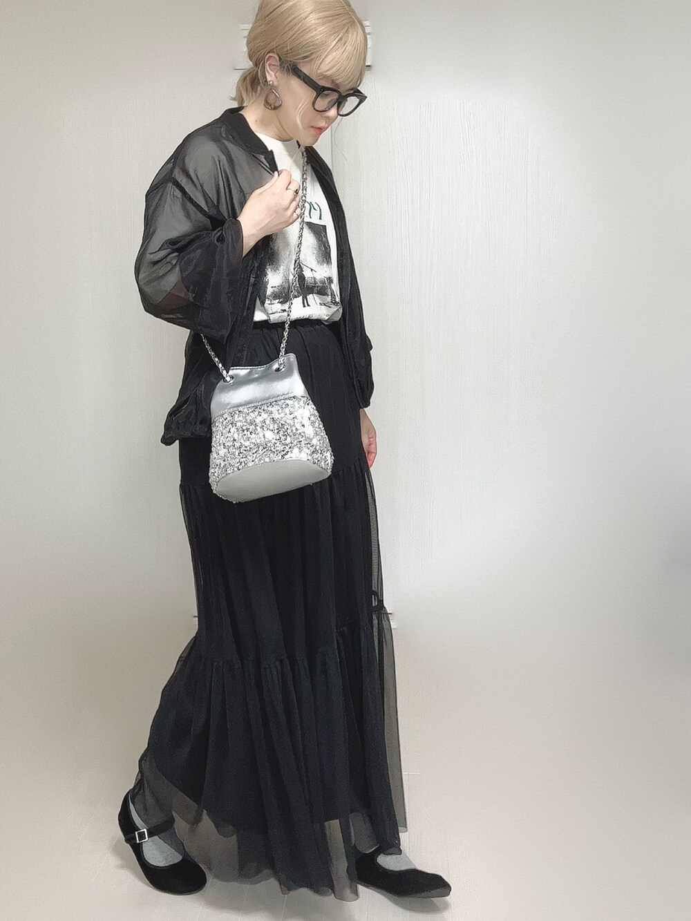 ブラック系のスカート、ホワイト系のTシャツ/カットソー、シルバー系のショルダーバッグを着用したレディースの秋コーディネートの4枚目の写真
