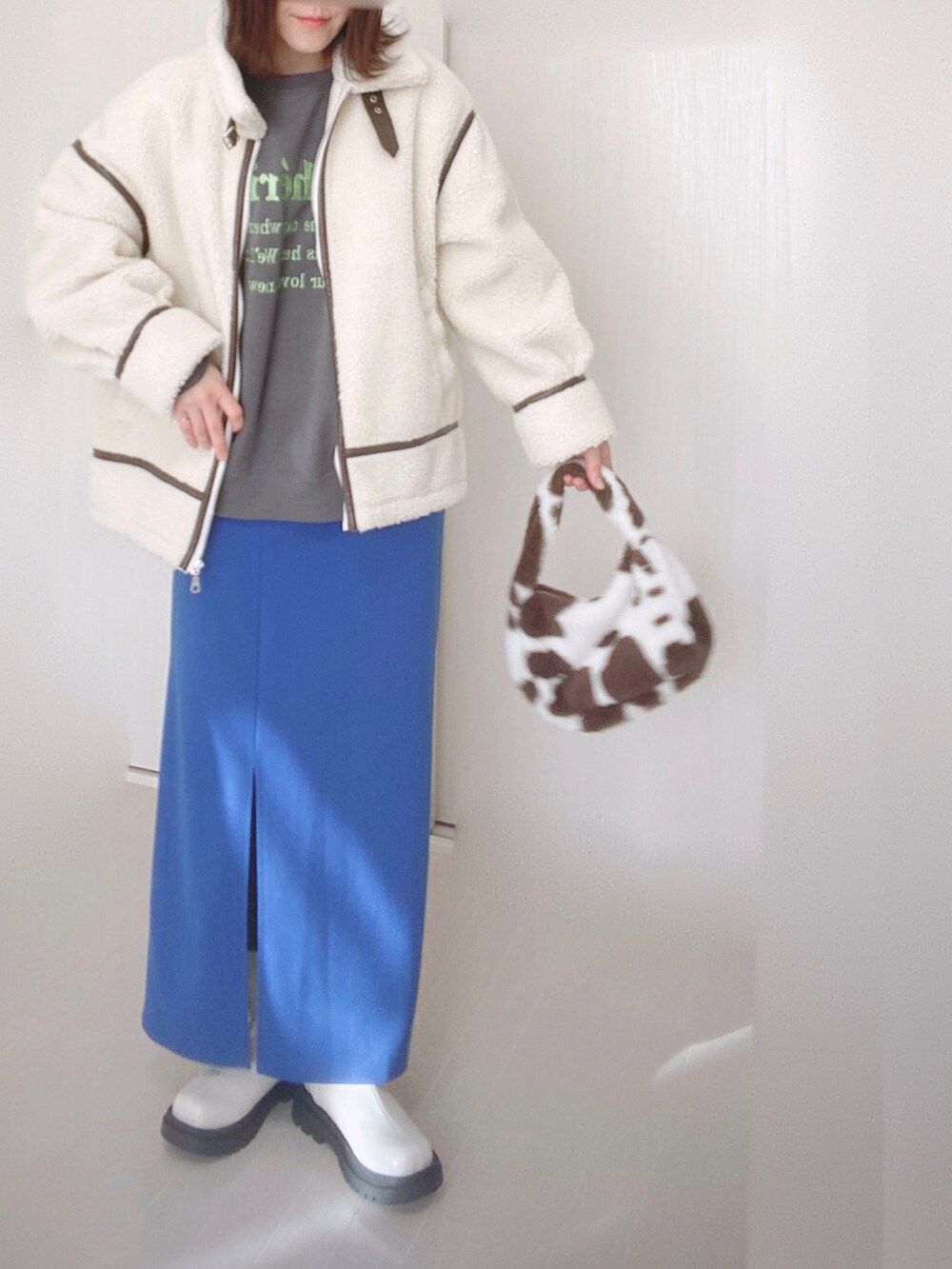 ホワイト系のブルゾン、グレー系のスウェット、ブルー系のスカートを着用したレディースの秋コーディネートの2枚目の写真