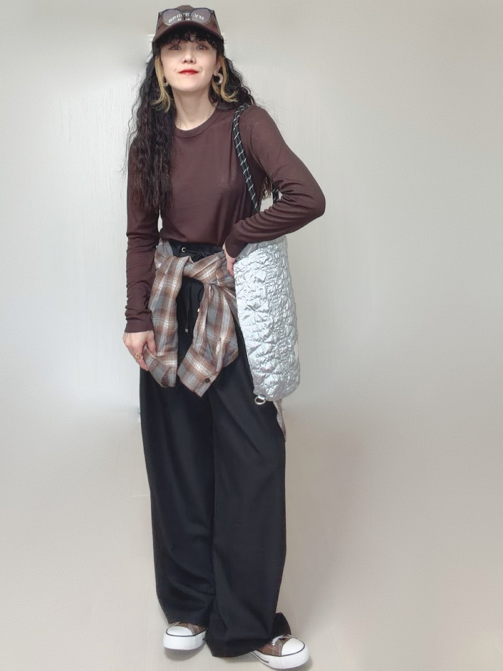 ブラウン系のシャツ/ブラウス、ブラック系のスラックス、シルバー系のトートバッグを着用したレディースの春コーディネートの2枚目の写真