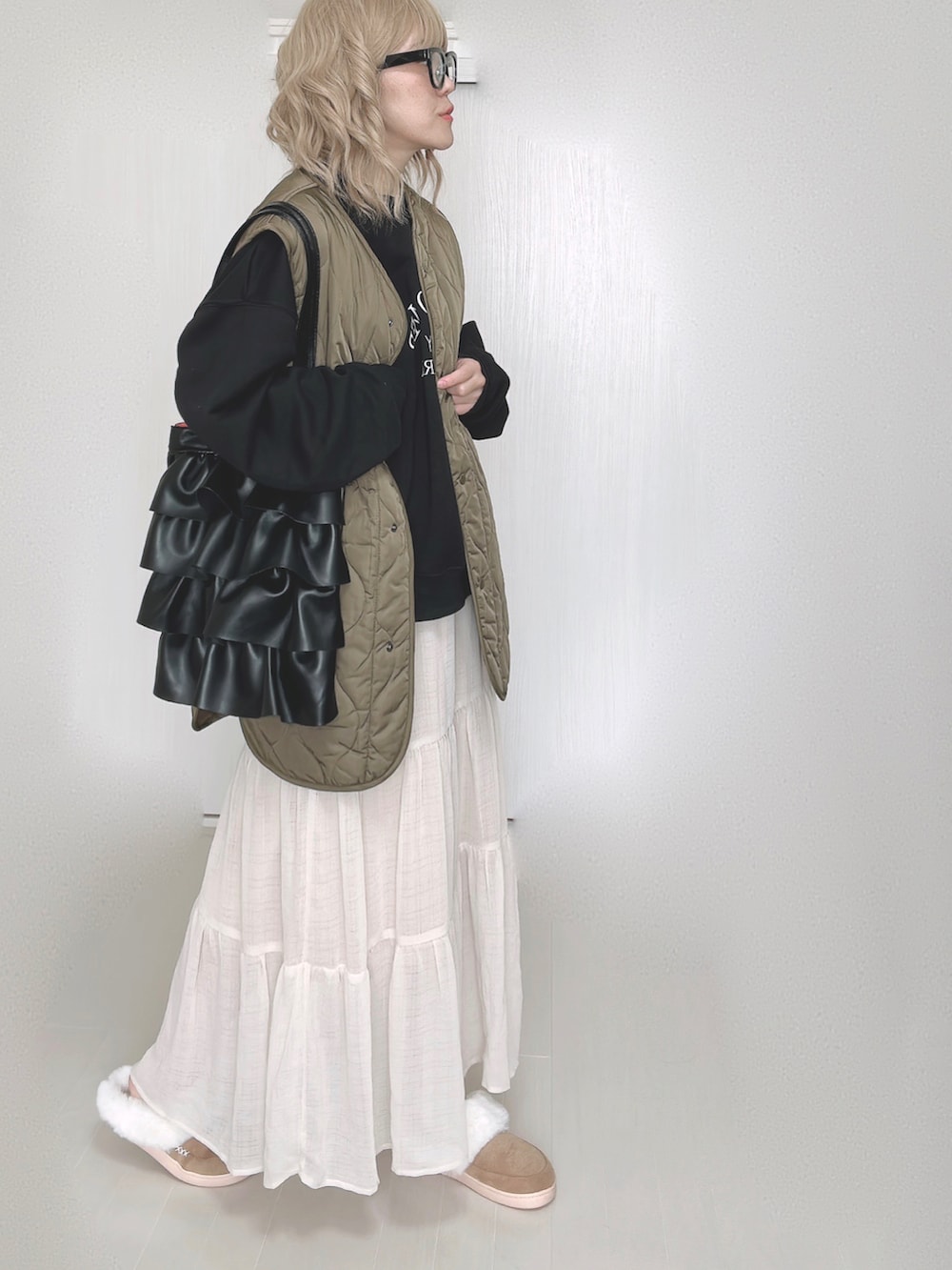 ブラック系のスウェット、ホワイト系のスカートを着用したレディースの秋コーディネートの5枚目の写真