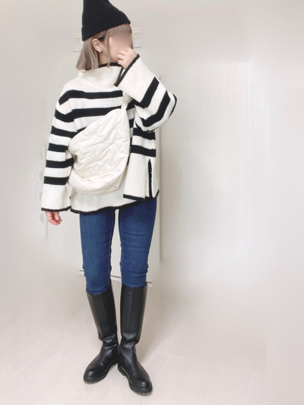 ブラック系のブーツ、ホワイト系のニット/セーター、ホワイト系のショルダーバッグを着用したレディースの秋コーディネートの4枚目の写真